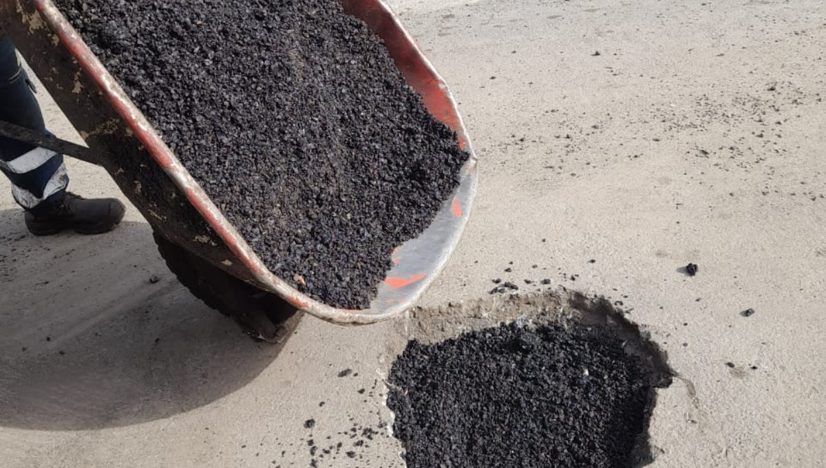 Mezcla asfáltica en frío BACHEX volcada sobre un bache, apta para bacheo con lluvia e invierno