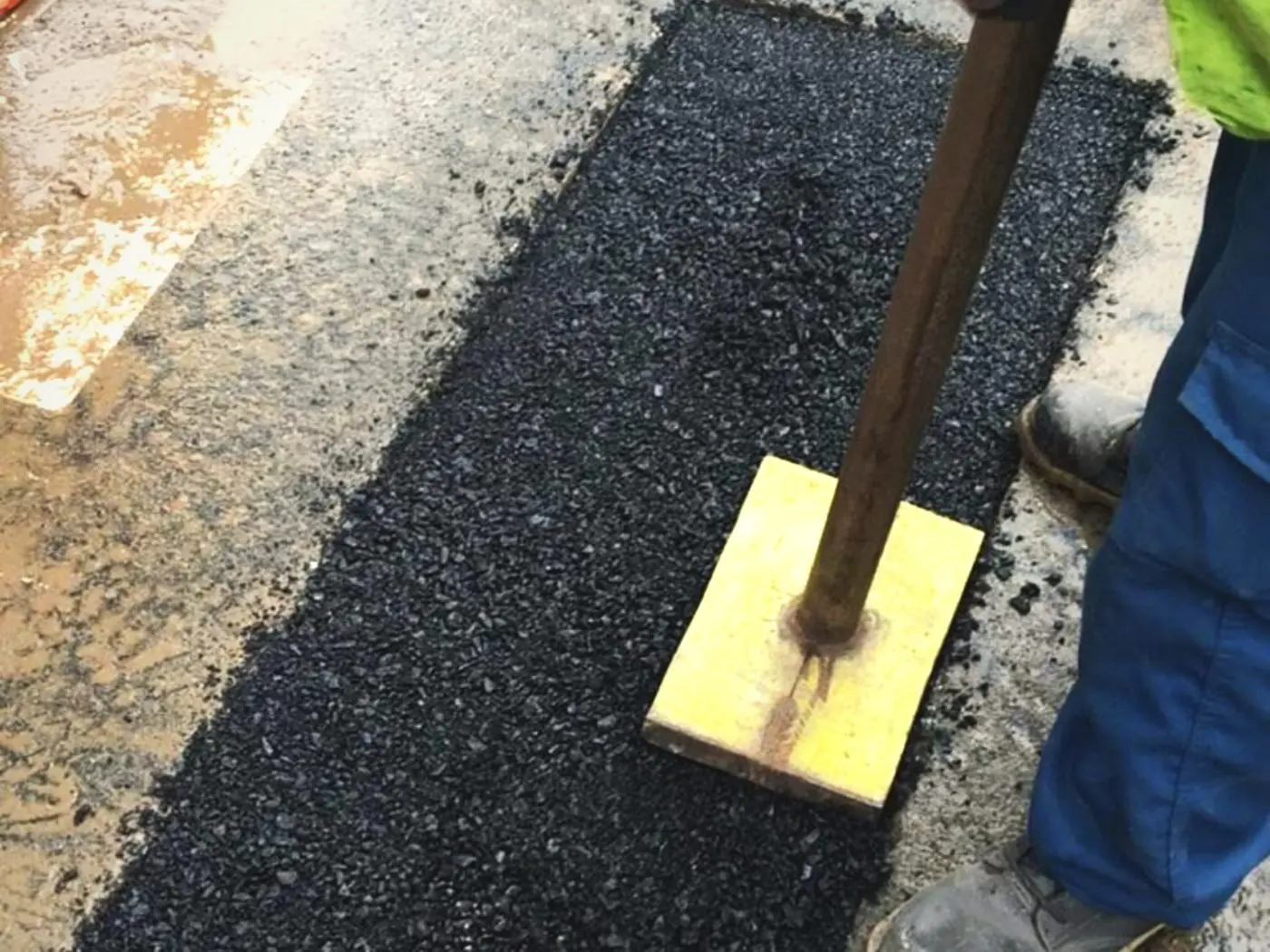 Compactación con pisón manual de un bache relleno con mezcla asfáltica en frío BACHEX: bacheo y reparación terminados